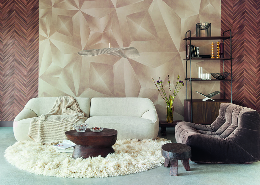 Bild Tapeten in einem modernen Wohnzimmer mit geometrischen Tapeten, beigem Sofa, dunklem Sessel und Holzmöbeln.