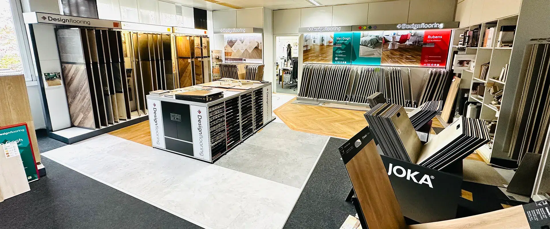 Willkommen in unserem Ausstellungsraum, wo Sie eine Vielzahl von Bodenbelagsmustern erkunden können, von elegantem Holz bis zu strapazierfähigem Vinyl. Erfahren Sie mehr über uns (Über uns) auf unseren Informationsschildern und Broschüren, die in Ausstellungsständern ausliegen. - T&K WOHNSTDIO - Raumausstattung, Bodenbeläge, Vinylboden, Parkett, Gardinen - Saarburger Straße 25, 67071 Ludwigshafen