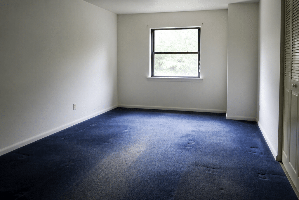 Vorher: Zimmer mit altem abgenutztem Teppichboden