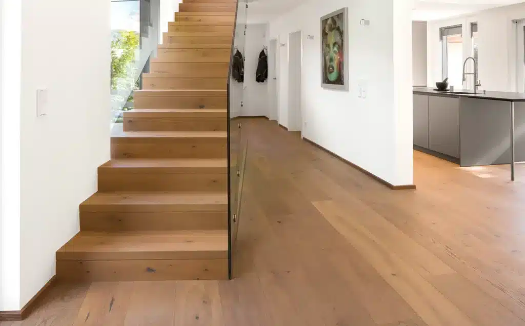 Moderne Eichentreppe mit Glasgelaender und breiten Dielen